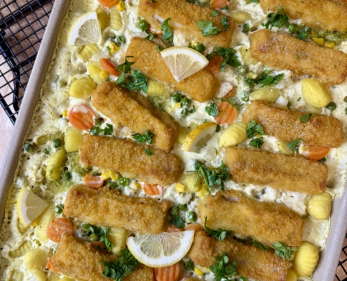 Cremiges Fischstäbchen-Gnocchi-Blech mit Buttergemüse auf dem Pampered Chef Großen Ofenzauberer, garniert mit frischer Petersilie und Zitronenspalten