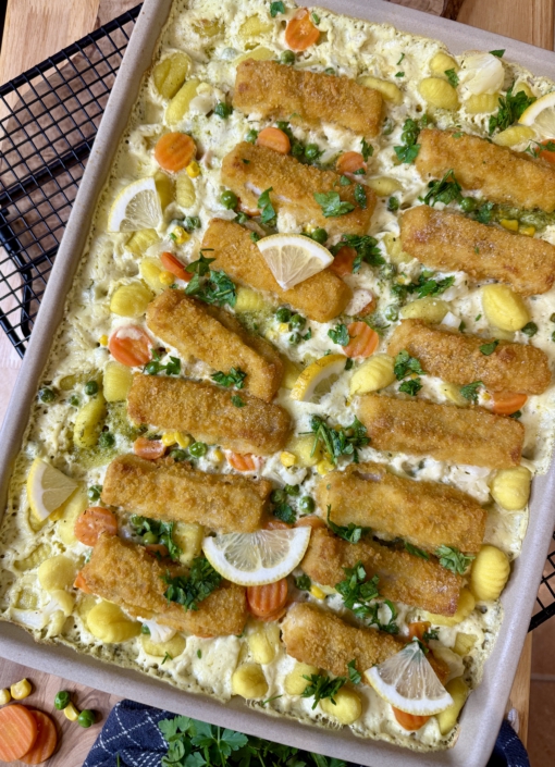 Cremiges Fischstäbchen-Gnocchi-Blech mit Buttergemüse auf dem Pampered Chef Großen Ofenzauberer, garniert mit frischer Petersilie und Zitronenspalten